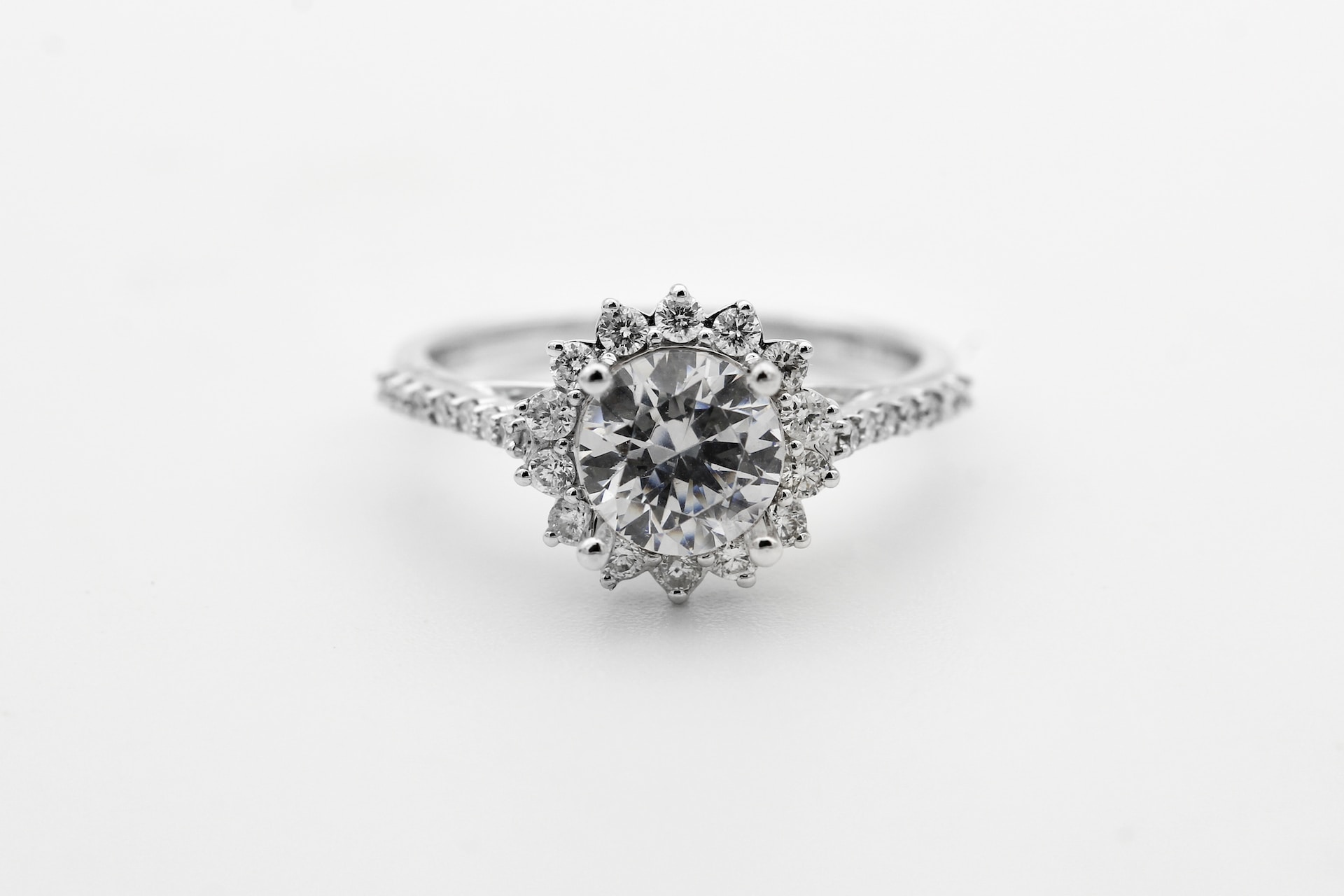 a platinum diamond engagement ring with a blooming halo and diamonds all around the band.