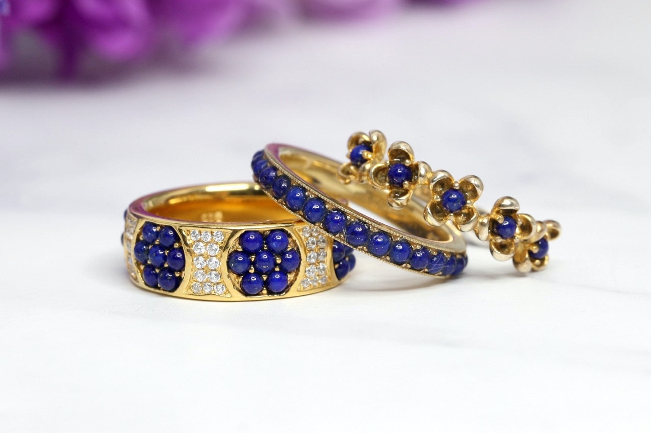 three yellow gold and gemstone engagement rings