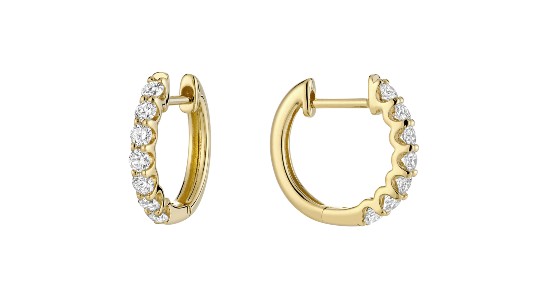 a pair of yellow gold huggie earrings with prong set diamonds