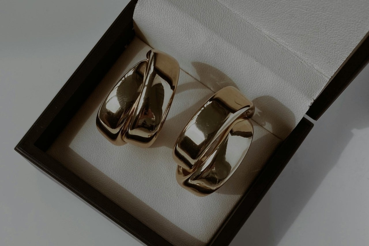 a pair of chunky silver toned earrings in a gift box