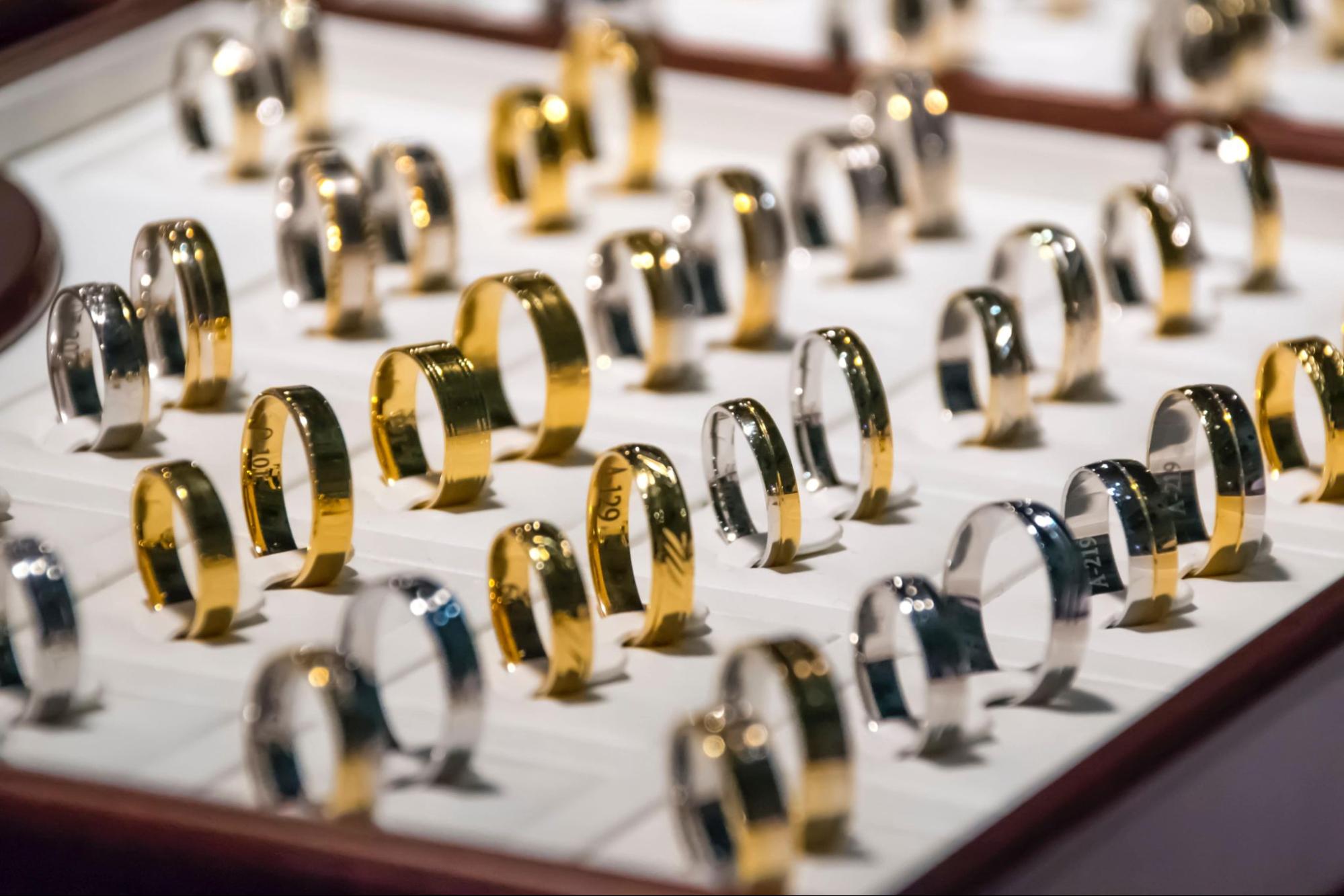A close up of an array of white and yellow gold polished wedding bands.