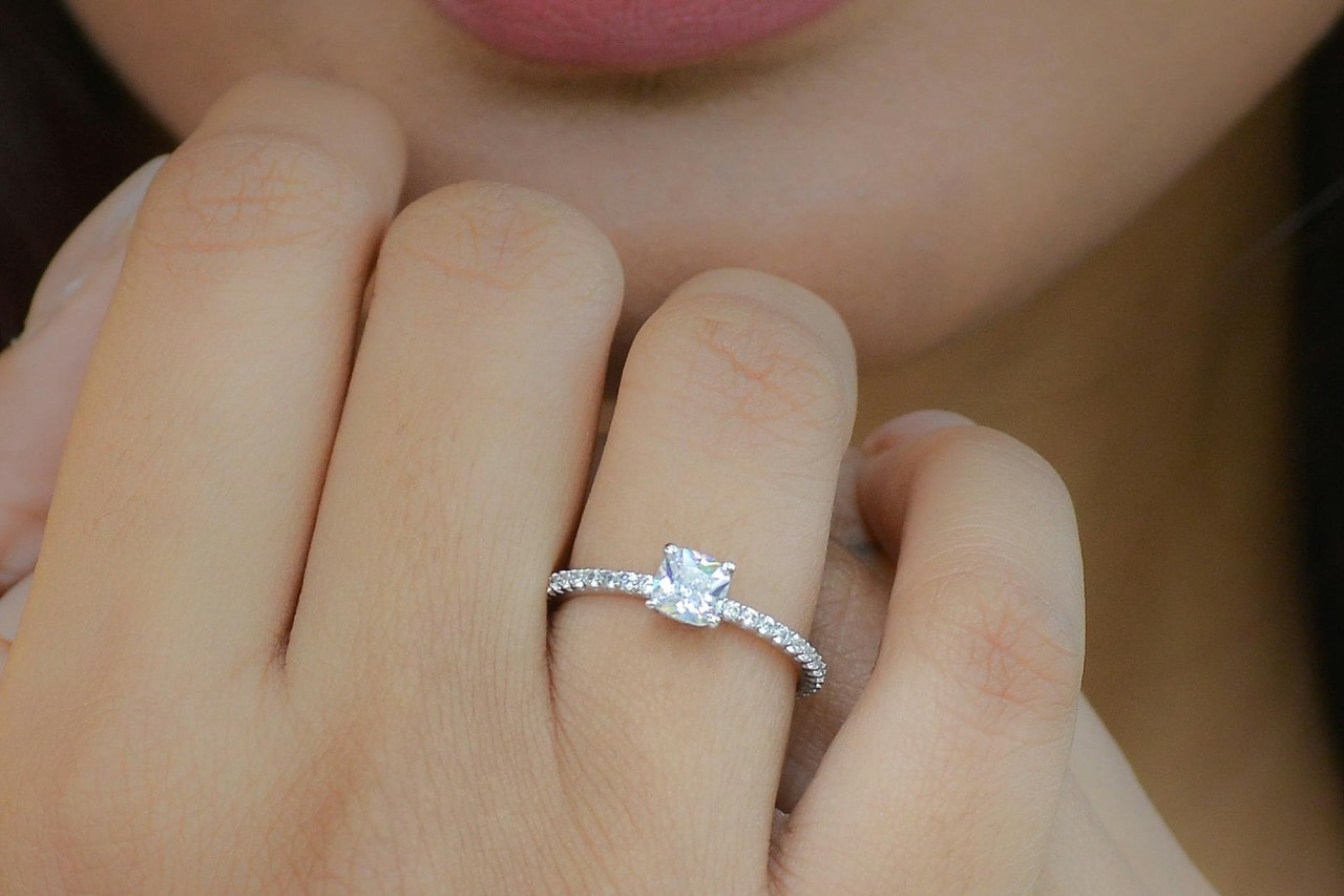 A close-up of a princess cut white gold diamond engagement ring on a woman’s hand A close-up of a princess cut white gold diamond engagement ring on a woman’s hand