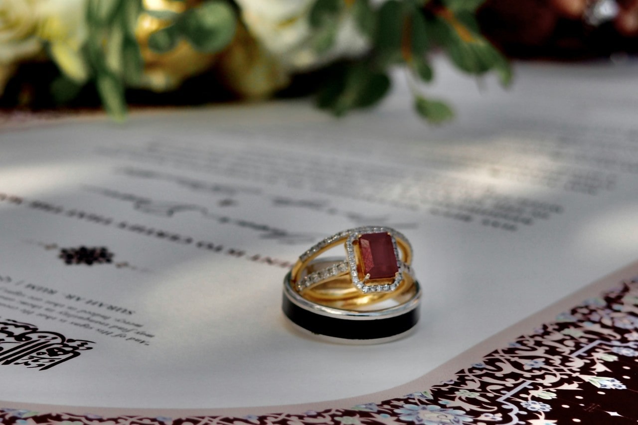 a stack of wedding bands and an engagement ring featuring a ruby centre stone. a stack of wedding bands and an engagement ring featuring a ruby centre stone.