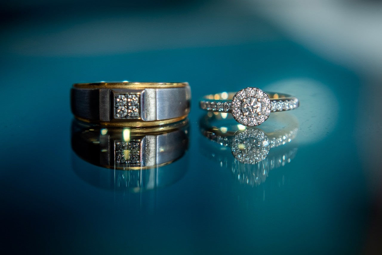 diamond engagement ring and wedding band on a blue background