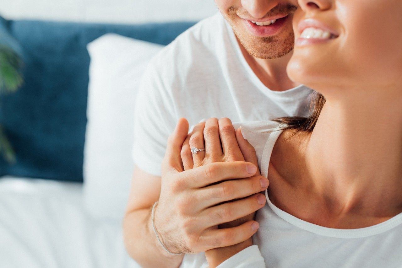 couple holding hands showing her engagement ring