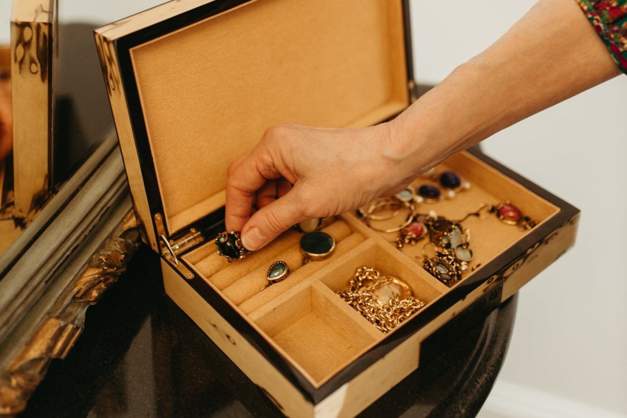 A woman selects an onyx ring from her jewellery collection.